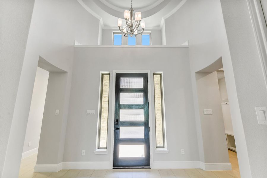 Beautiful entry way with decorative shelf and rotunda with chandelier that leads to the open living area. Beautiful entry way with decorative shelf and rotunda with chandelier that leads to the open living area.
