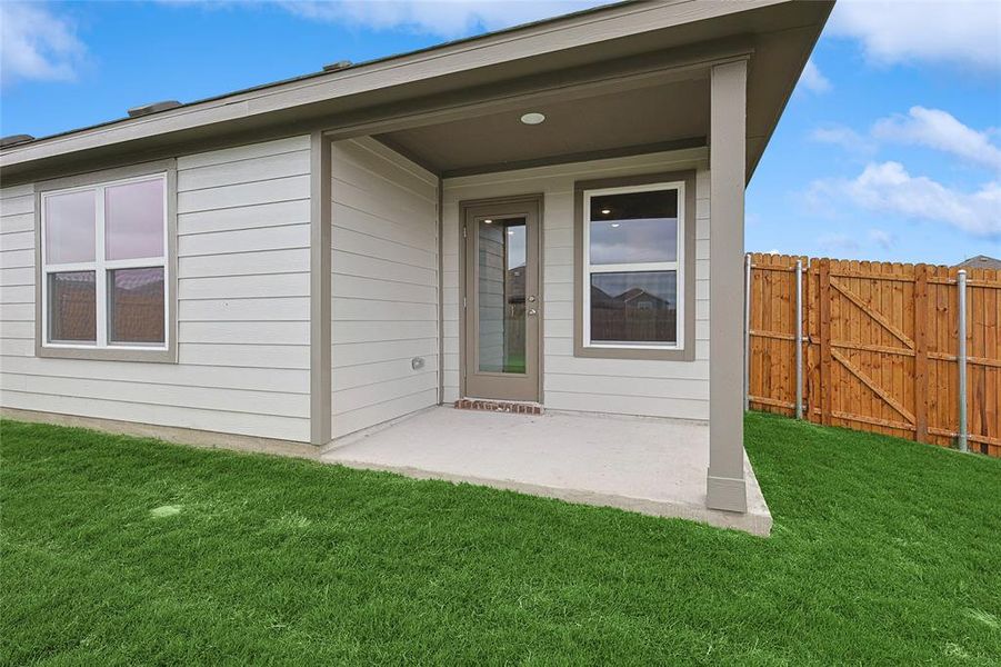 Doorway to property featuring a patio area and a yard