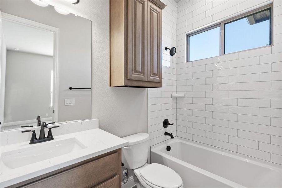 Bathroom featuring  shower combination, vanity, and a textured wall
