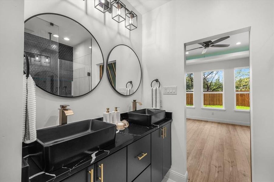 Full bathroom with light wood-style flooring, a stall shower, double vanity, recessed lighting, and ceiling fan