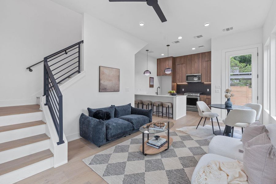Living area featuring stairway, ceiling fan, light wood finished floors, and recessed lighting