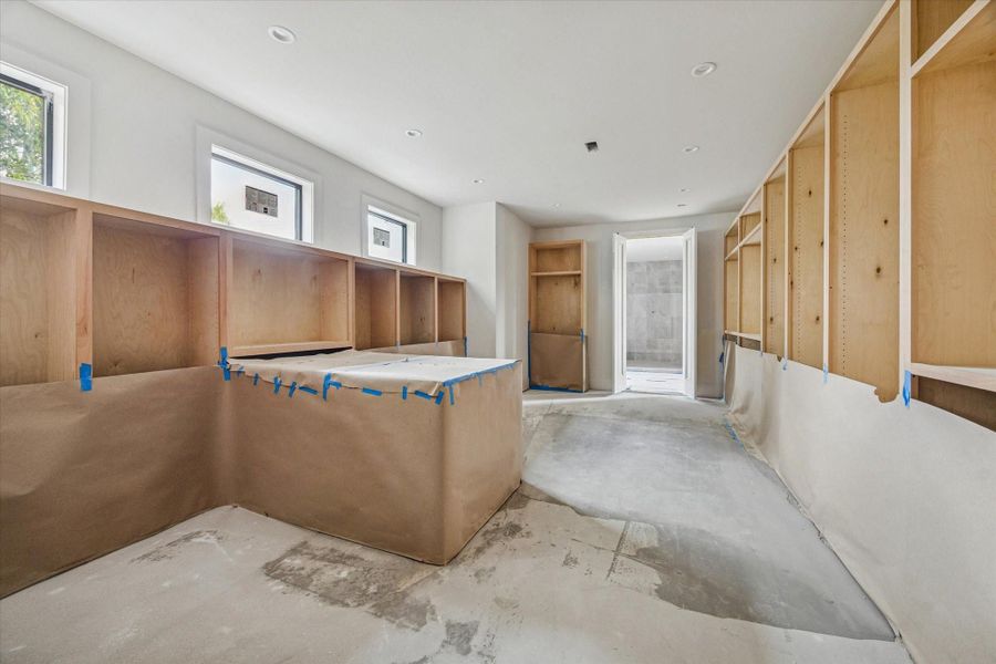 Oversized primary closet with natural light and custom cabinetry. Oversized primary closet with natural light and custom cabinetry.