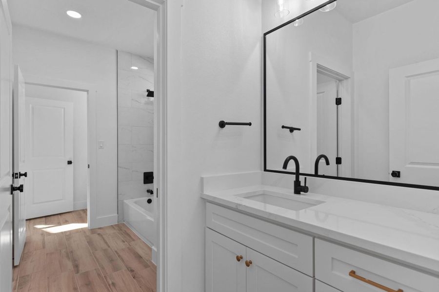 Bathroom with vanity, light wood-style floors, recessed lighting, and bathtub / shower combination Bathroom with vanity, light wood-style floors, recessed lighting, and bathtub / shower combination