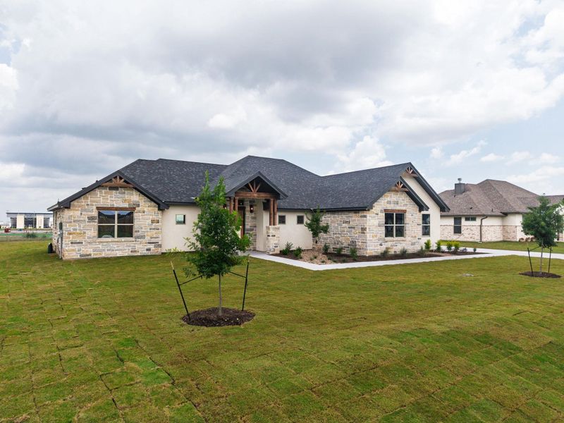 A newly sodded lawn leads to this impressive stone and stucco residence with rustic wood beam accents. A newly sodded lawn leads to this impressive stone and stucco residence with rustic wood beam accents.