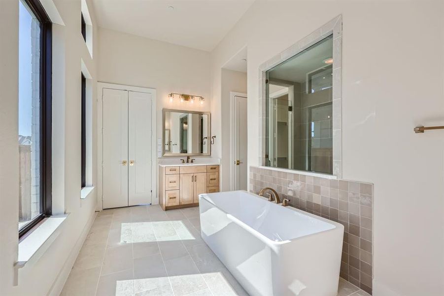 Bathroom featuring vanity, a bathtub, and tile patterned floors