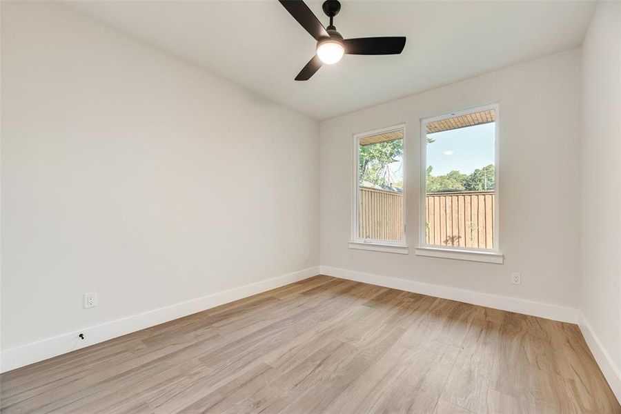 Spare room featuring light wood-style flooring and a ceiling fan Spare room featuring light wood-style flooring and a ceiling fan