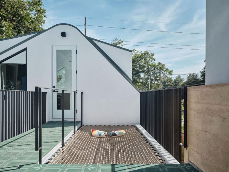 The detached guest suite/home office with it’s own bathroom above the garage—connected by a bridge clad in the new Rock Paper Build tiles from Clay Imports and a suspended hammock net, floating 10 feet in the air, creating a whimsical and social space 10 feet in the air. The detached guest suite/home office with it’s own bathroom above the garage—connected by a bridge clad in the new Rock Paper Build tiles from Clay Imports and a suspended hammock net, floating 10 feet in the air, creating a whimsical and social space 10 feet in the air.