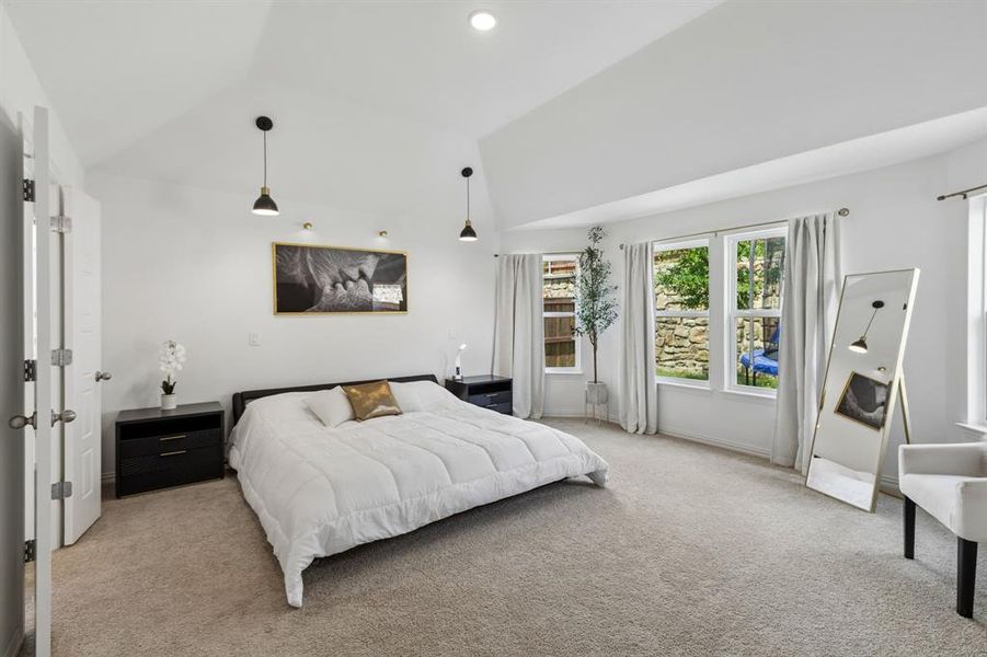 Spacious bedroom featuring light neutral carpeting and white wall finishes