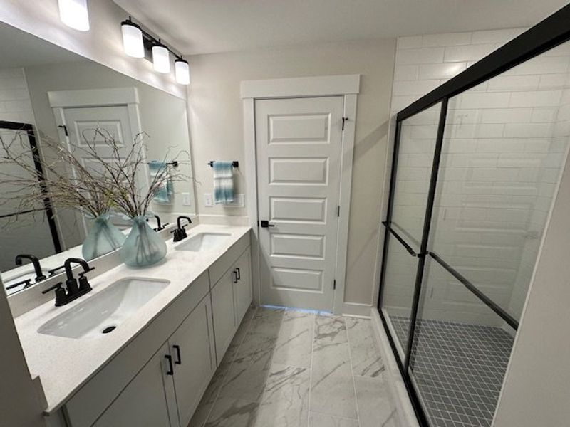 Modern bathroom featuring dual sinks, a spacious s