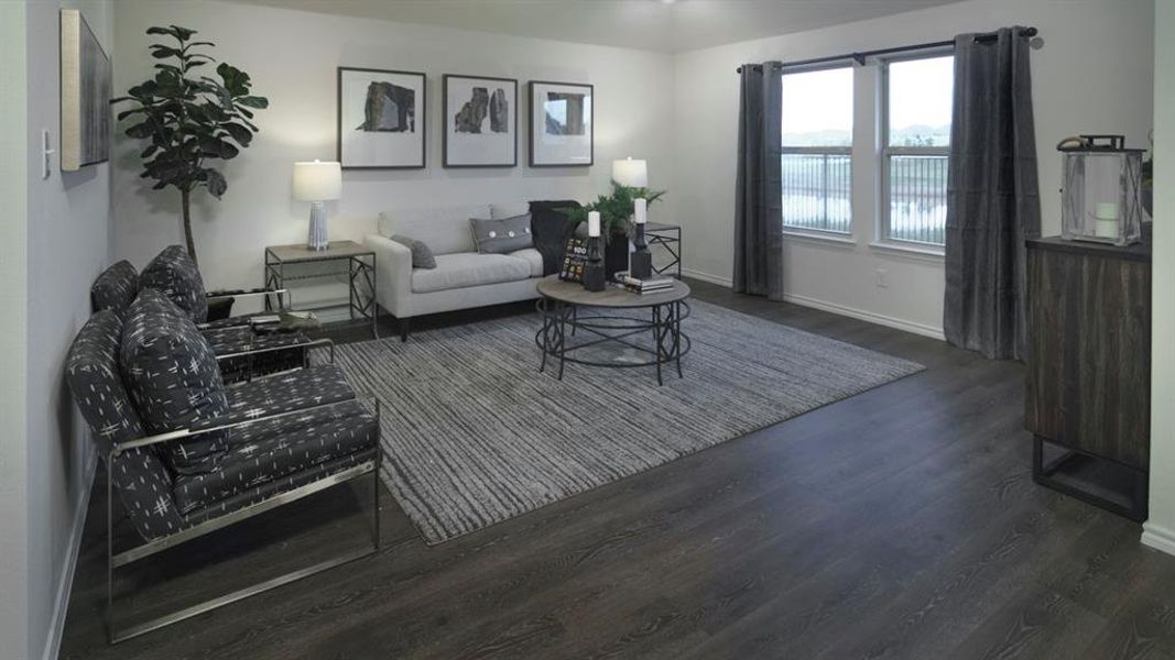 Spacious room featuring wood-finish flooring and a series of windows Spacious room featuring wood-finish flooring and a series of windows