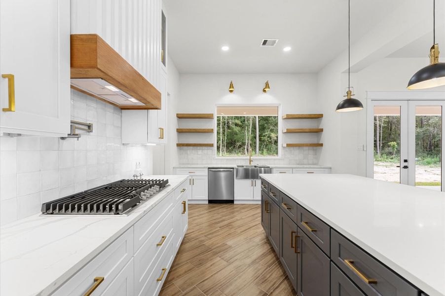 Chef’s dream kitchen featuring custom cabinetry, oversized island, quartz counters, modern fixtures, and abundant windows that overlook the backyard. Chef’s dream kitchen featuring custom cabinetry, oversized island, quartz counters, modern fixtures, and abundant windows that overlook the backyard.