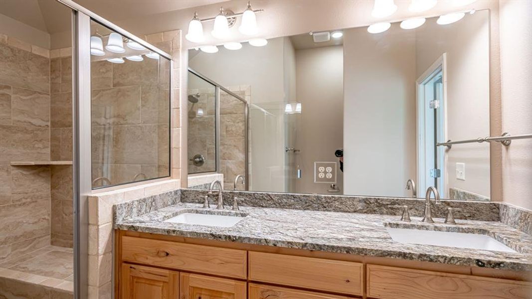 Full bathroom with double vanity and a stall shower