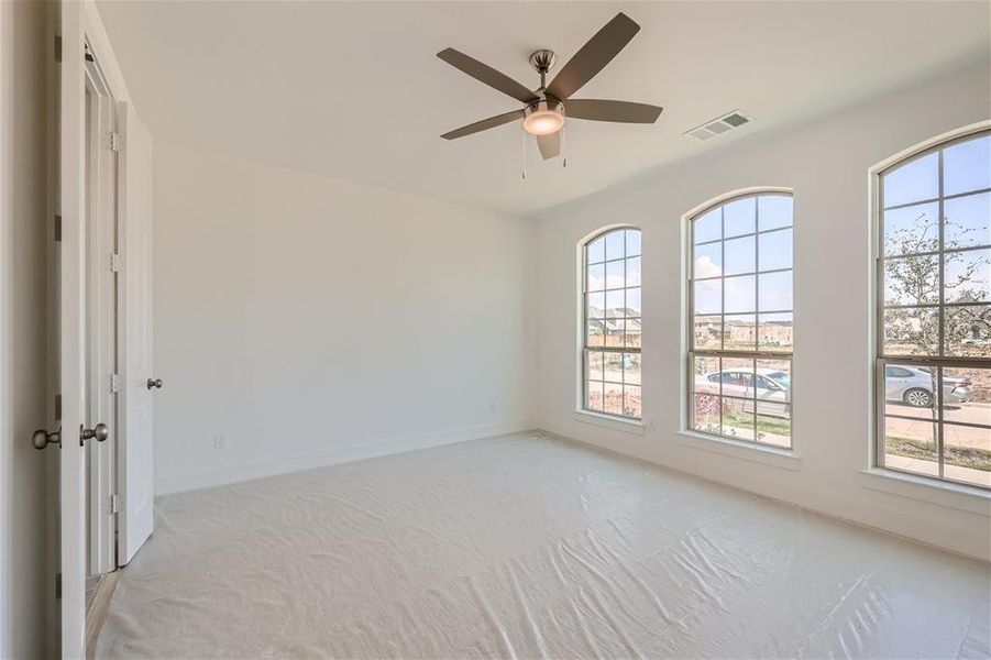 Carpeted empty room featuring ceiling fan