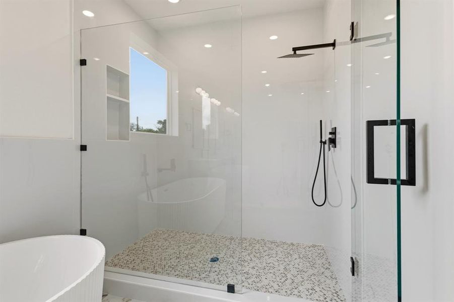 Modern bathroom featuring a glass-enclosed shower with a mosaic tile floor, matte black shower fixtures, and a free-standing bathtub