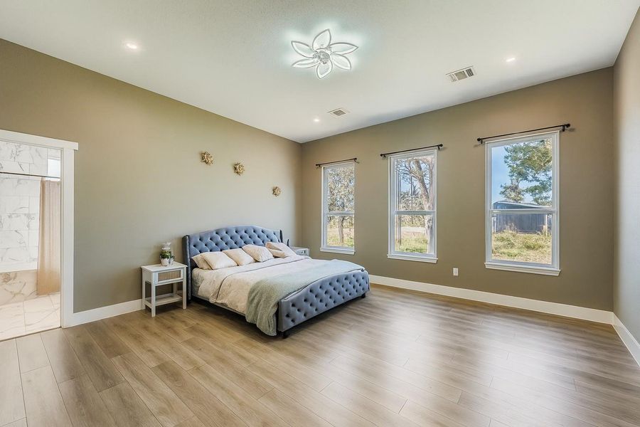 Bedroom with baseboards and light wood-type flooring Bedroom with baseboards and light wood-type flooring