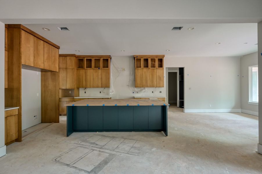 A spacious, open-concept kitchen with light wood cabinetry and a large island. This is the perfect home for entertaining family and friends.