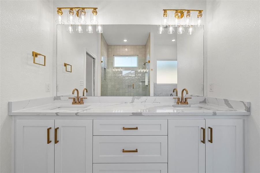 Bathroom featuring double vanity, a shower stall, and a textured wall