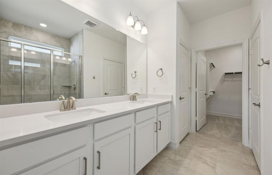 Elegant owner's bathroom with dual vanity and oversized shower*real home pictured