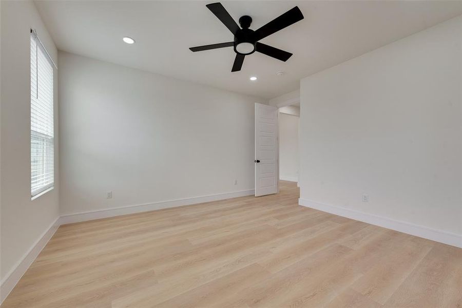 Spare room featuring ceiling fan, a healthy amount of sunlight, and light hardwood / wood-style floors