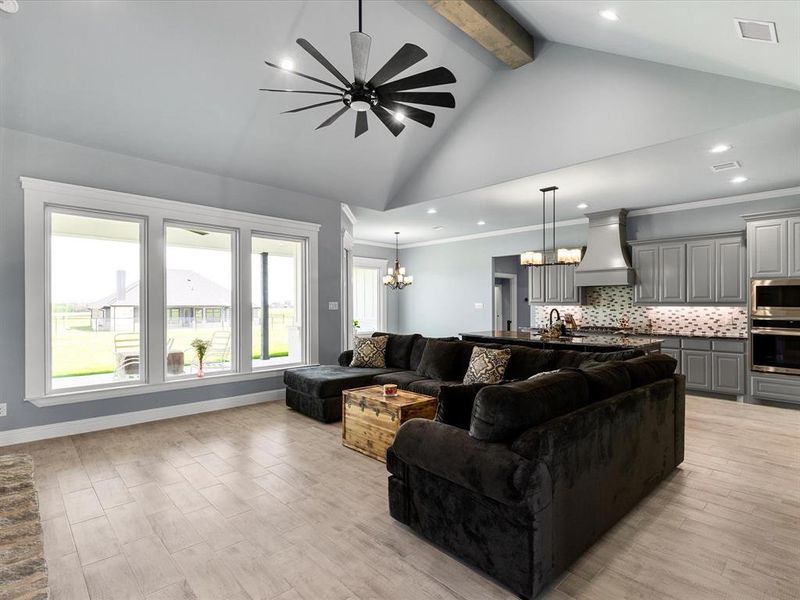 Living room featuring a chandelier, beamed ceiling, high vaulted ceiling, light wood-style floors, and recessed lighting Living room featuring a chandelier, beamed ceiling, high vaulted ceiling, light wood-style floors, and recessed lighting