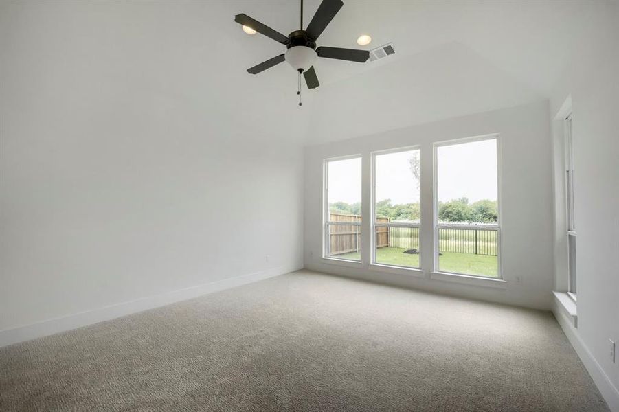 Bright interior space featuring a vaulted ceiling and a ceiling fan with integrated lighting Bright interior space featuring a vaulted ceiling and a ceiling fan with integrated lighting