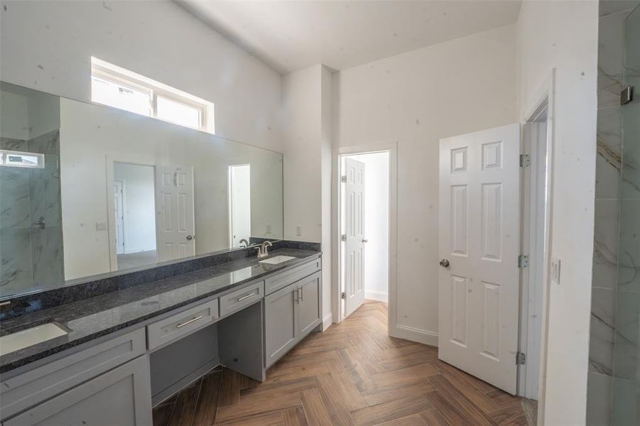 Full bathroom with a marble finish shower, double vanity, a high ceiling, and parquet floors