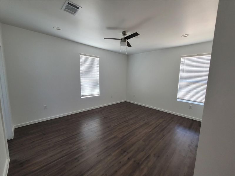 Rich hardwood-style flooring and abundant natural light define this inviting sleeping space.