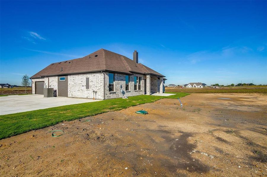 Rear view of property featuring a lawn and a garage