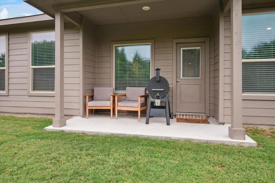Doorway to backyard featuring a covered patio and a lawn. Doorway to backyard featuring a covered patio and a lawn.