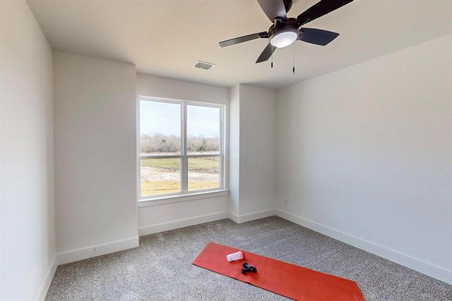 Carpeted empty room featuring ceiling fan