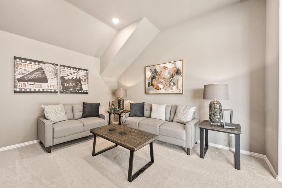 Living room with two gray sofas, wood coffee table, vaulted ceiling, and carpet flooring Living room with two gray sofas, wood coffee table, vaulted ceiling, and carpet flooring