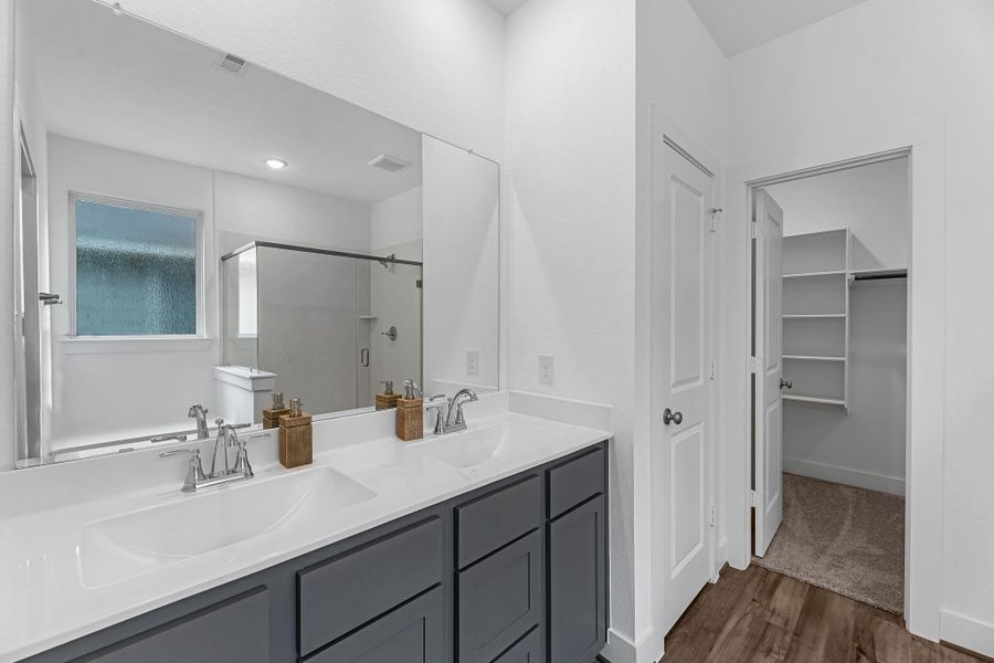 The en-suite bathroom offers a spa-like atmosphere with its elegant design, high end finishes, and tasteful lighting, creating a retreat within your own home.