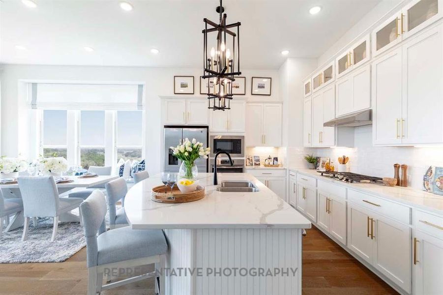 Kitchen with tasteful backsplash, white cabinets, light stone counters, dark wood-style floors, and recessed lighting Kitchen with tasteful backsplash, white cabinets, light stone counters, dark wood-style floors, and recessed lighting