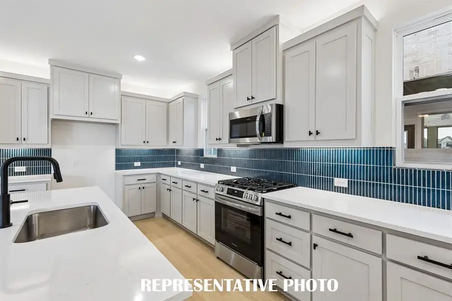 With ample cabinetry, gorgeous counter tops and a wonderful POP of color in the backsplash, all the chefs in the family will love creating in this dream kitchen!  REPRESENTATIVE PHOTO