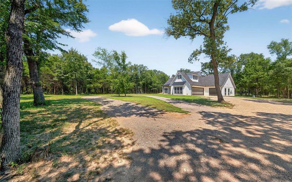 View of front of home with dirt driveway and a front lawn View of front of home with dirt driveway and a front lawn