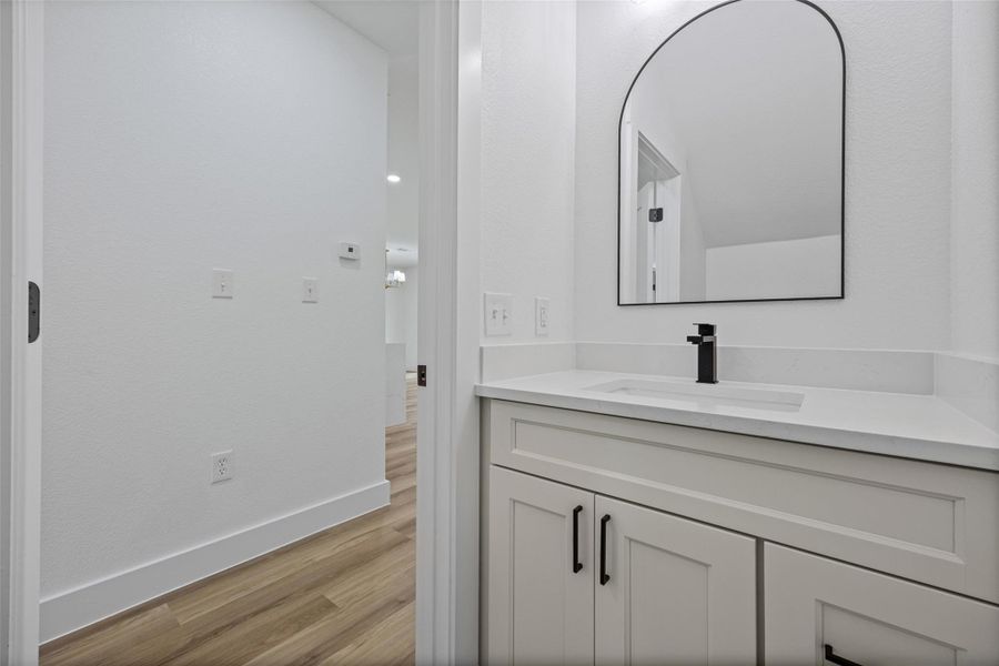 Half Bathroom located on main floor. Vanity with storage featuring a quartz countertop, undermount sink, and matte black faucet Half Bathroom located on main floor. Vanity with storage featuring a quartz countertop, undermount sink, and matte black faucet