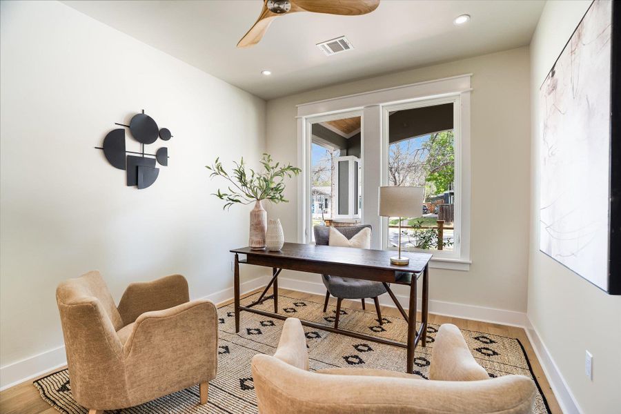 This room features recessed lighting, a ceiling fan, and hardwood floors This room features recessed lighting, a ceiling fan, and hardwood floors
