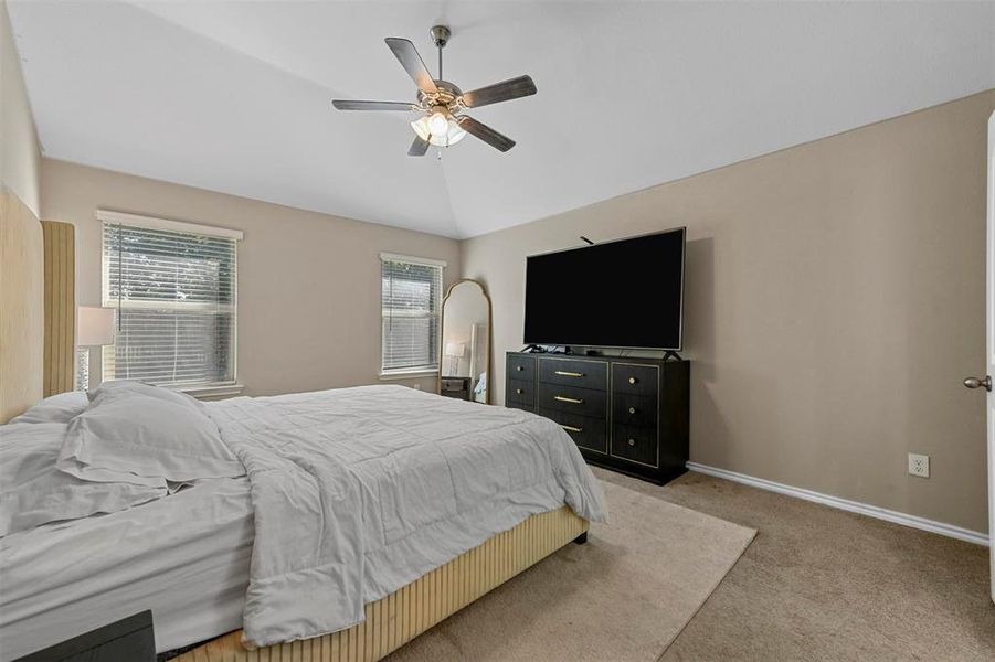 Bedroom with light carpet, vaulted ceiling, and ceiling fan