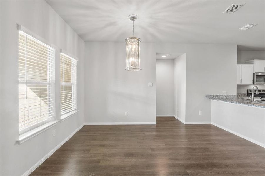 Unfurnished dining area featuring a chandelier, dark hardwood / wood-style flooring, and sink