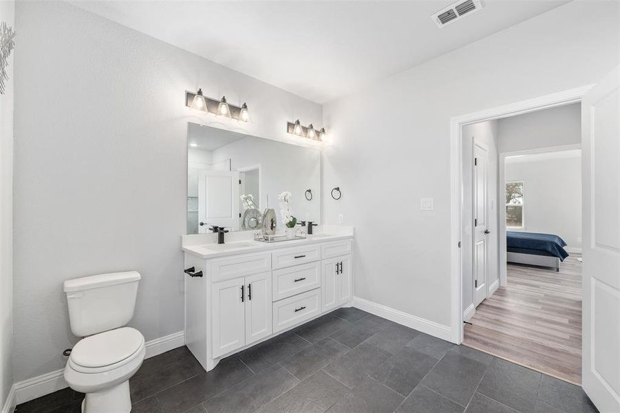 Bathroom featuring vanity, tile patterned floors, and toilet