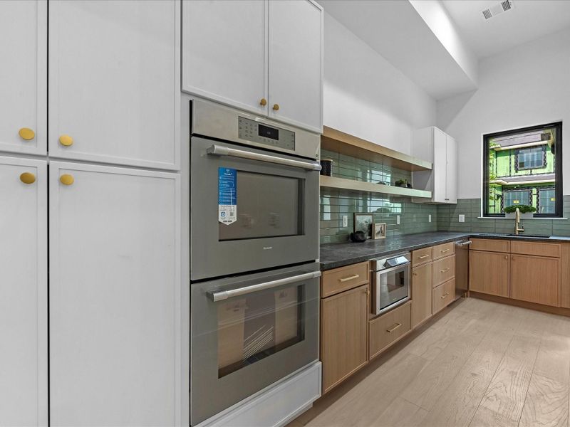 A spacious working pantry featuring Thermador double ovens, Thermador Microwave, an additional Thermador dishwasher, and a second sink. Extended counters with built-in outlets add both convenience and functionality.