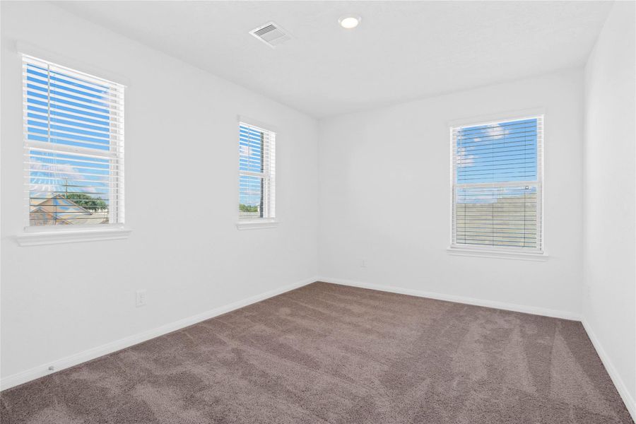 This inviting bedroom offers a bright and airy atmosphere with neutral walls, plush carpet flooring, and large windows that fills the space with natural light. This inviting bedroom offers a bright and airy atmosphere with neutral walls, plush carpet flooring, and large windows that fills the space with natural light.
