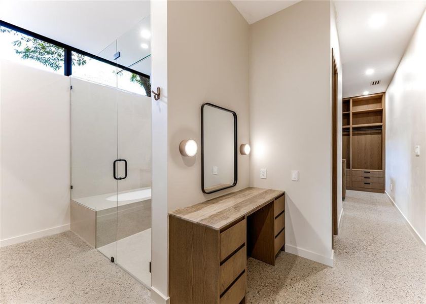 Full bath featuring a wet room with shower and tub, built in vanity, spacious closet and aggregate flooring