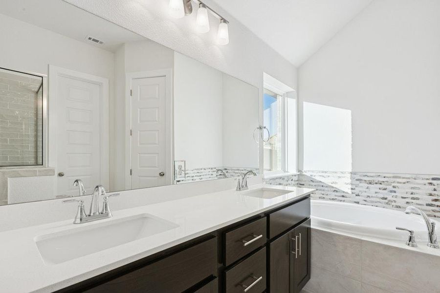 Bathroom with a bath, double vanity, vaulted ceiling, and a shower stall Bathroom with a bath, double vanity, vaulted ceiling, and a shower stall