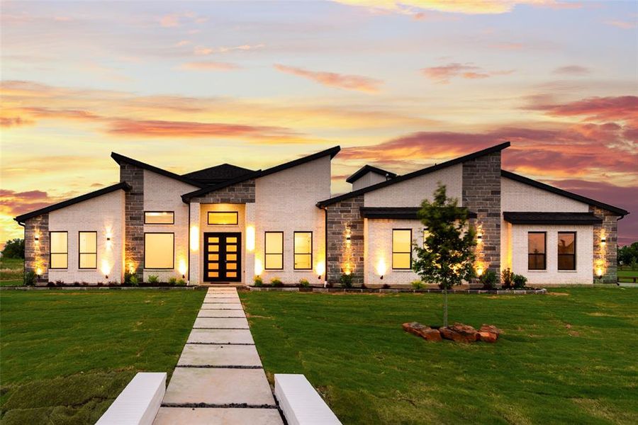 Contemporary home featuring brick siding, a front lawn, stone siding, and french doors Contemporary home featuring brick siding, a front lawn, stone siding, and french doors