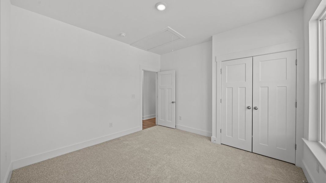 Accomplished design shines in this carpeted bedroom with a functional walk-in closet
