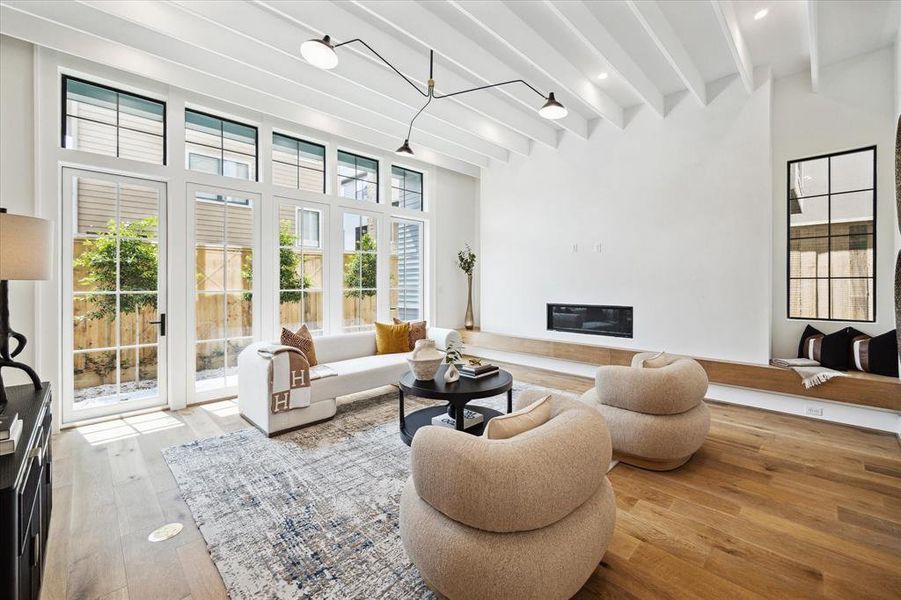 The floating white oak hearth complements the Chantilly White plastered fireplace surround and the linear fireplace with remote, while the brick wall provides warmth. Two sets of Lincoln aluminum doors provide easy access to the outdoors.