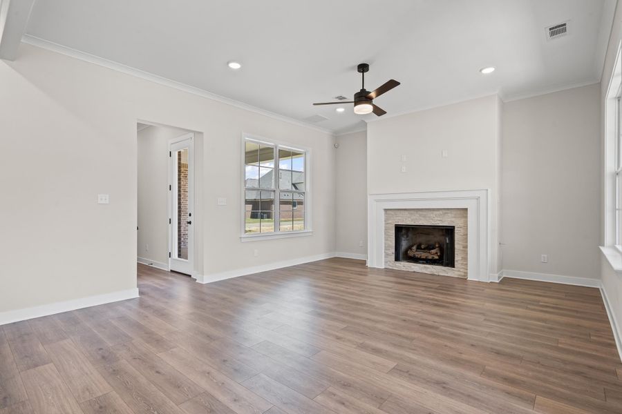 Unfurnished living room featuring crown molding, light wood-style floors, a fireplace, ceiling fan, and recessed lighting Unfurnished living room featuring crown molding, light wood-style floors, a fireplace, ceiling fan, and recessed lighting