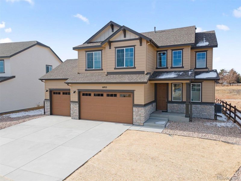 Front exterior of a new home in Highlands Preserve, Mead, CO, highlighting curb appeal (Image 2).