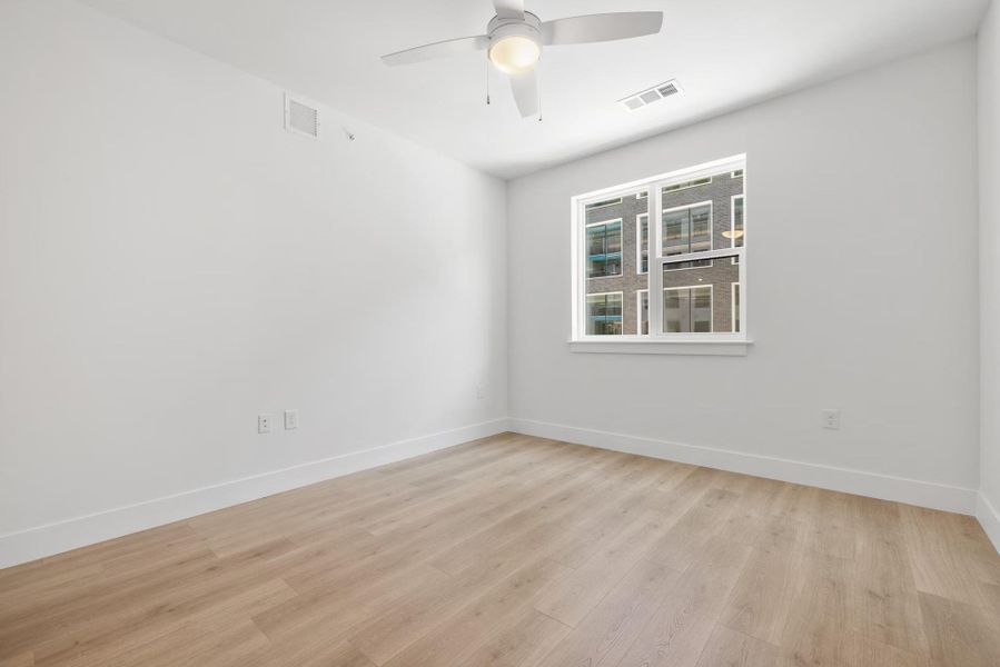 Empty room with light wood-type flooring and a ceiling fan